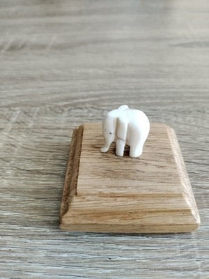 A small decorative elephant carving mounted on a neatly finished oak base. Its simple design makes it a charming and unique display piece.