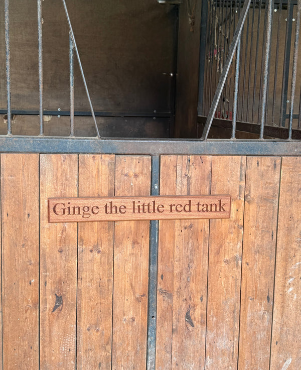 A handcrafted mahogany  name plaque engraved “Ginge the little red tank.” The warm wood grain and clean engraving make it a charming and personal decorative sign.